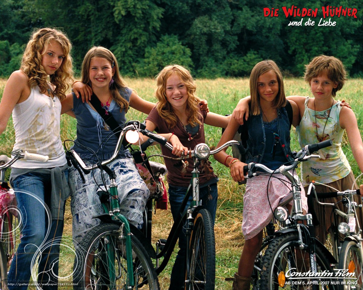 Five girls with bicycles in a field