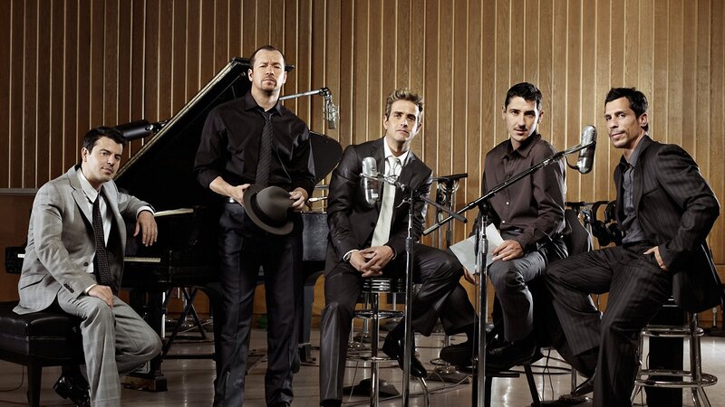 five men in suits in a recording studio