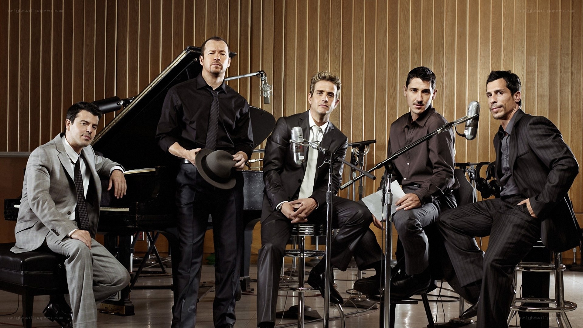 five men in suits in a recording studio