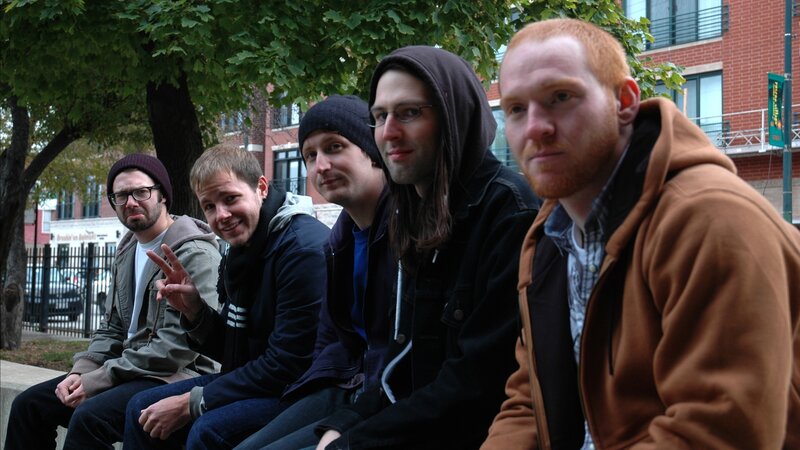 five men sitting on a bench