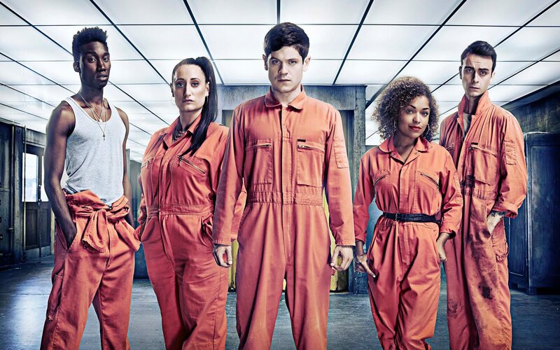 five people in orange jumpsuits
