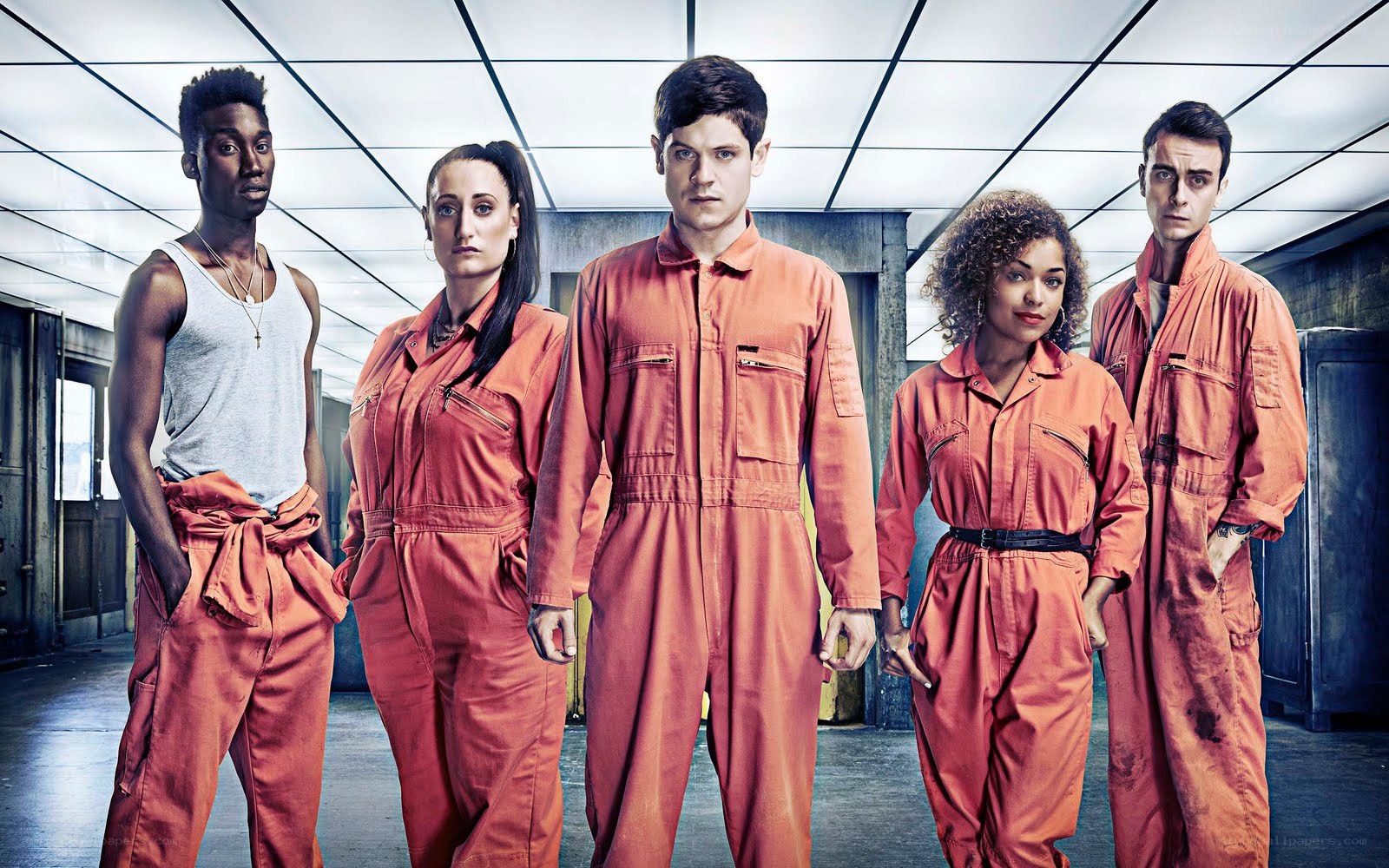 five people in orange jumpsuits