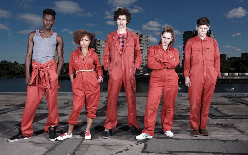 five people in red overalls
