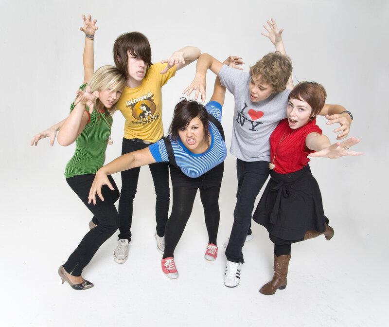 five teenagers posing playfully