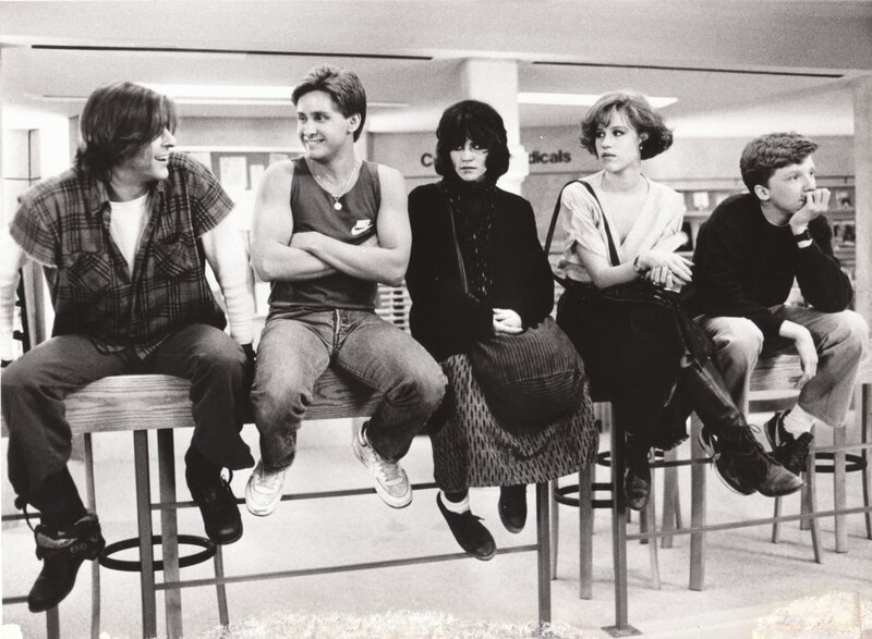 five teenagers sitting on stools