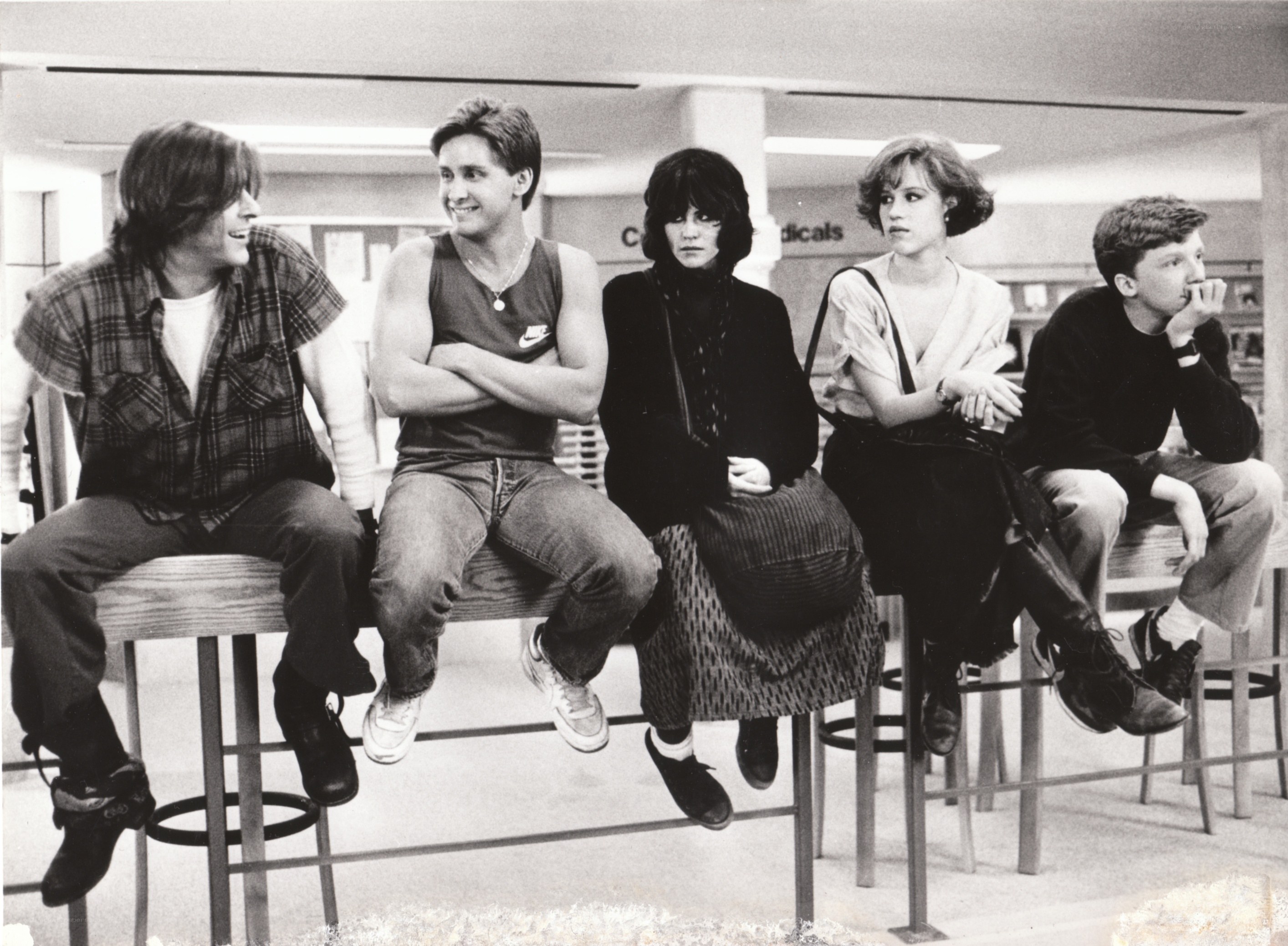 five teenagers sitting on stools