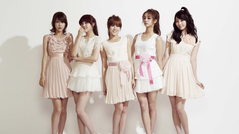five women in pastel dresses