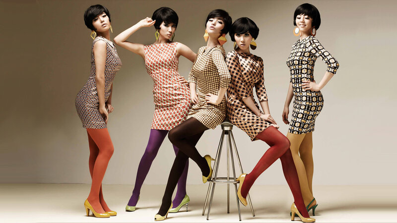 five women in patterned dresses