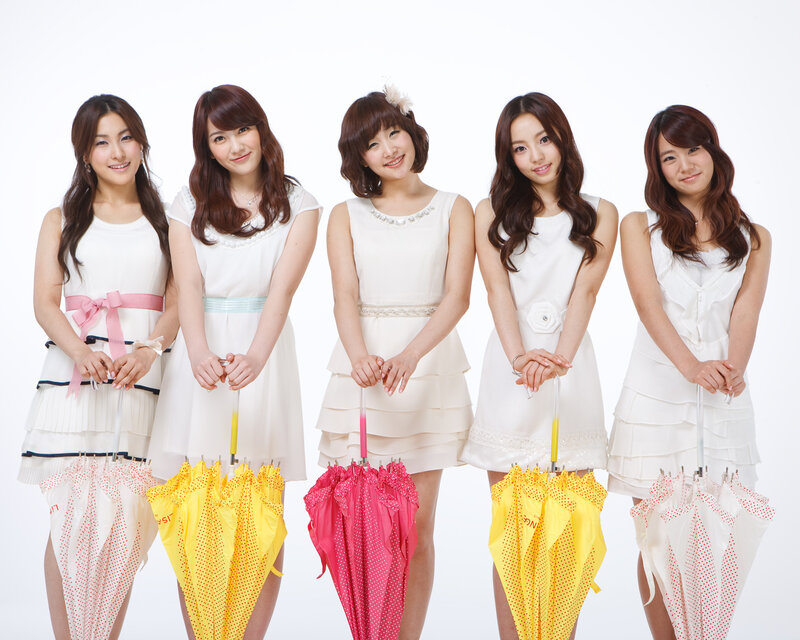 Five women in white dresses with umbrellas