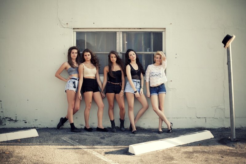 five women posing by a wall