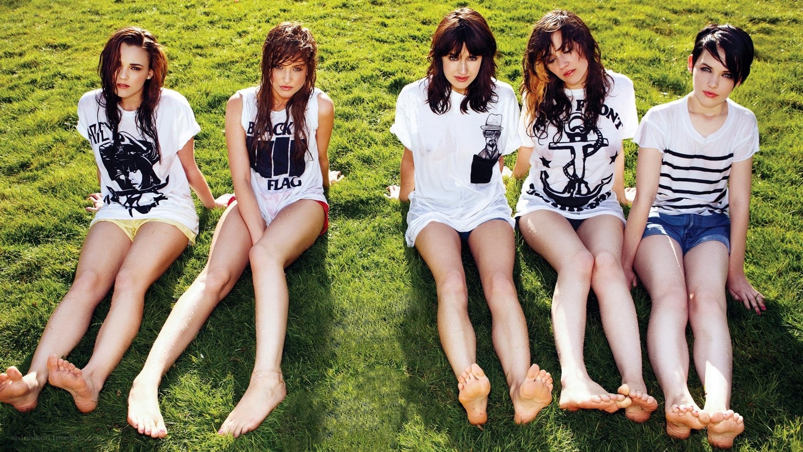 five women sitting on grass