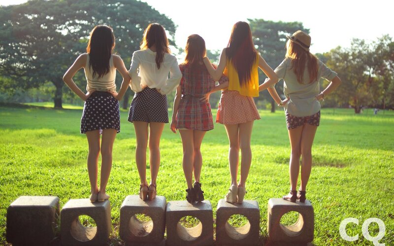 Five women standing on blocks in a park