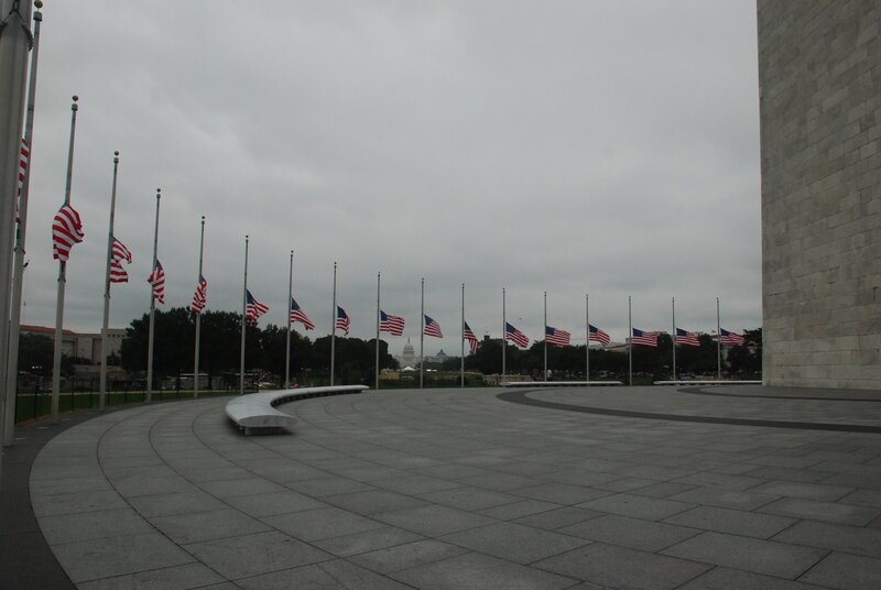 Flags at half-staff on a cloudy day