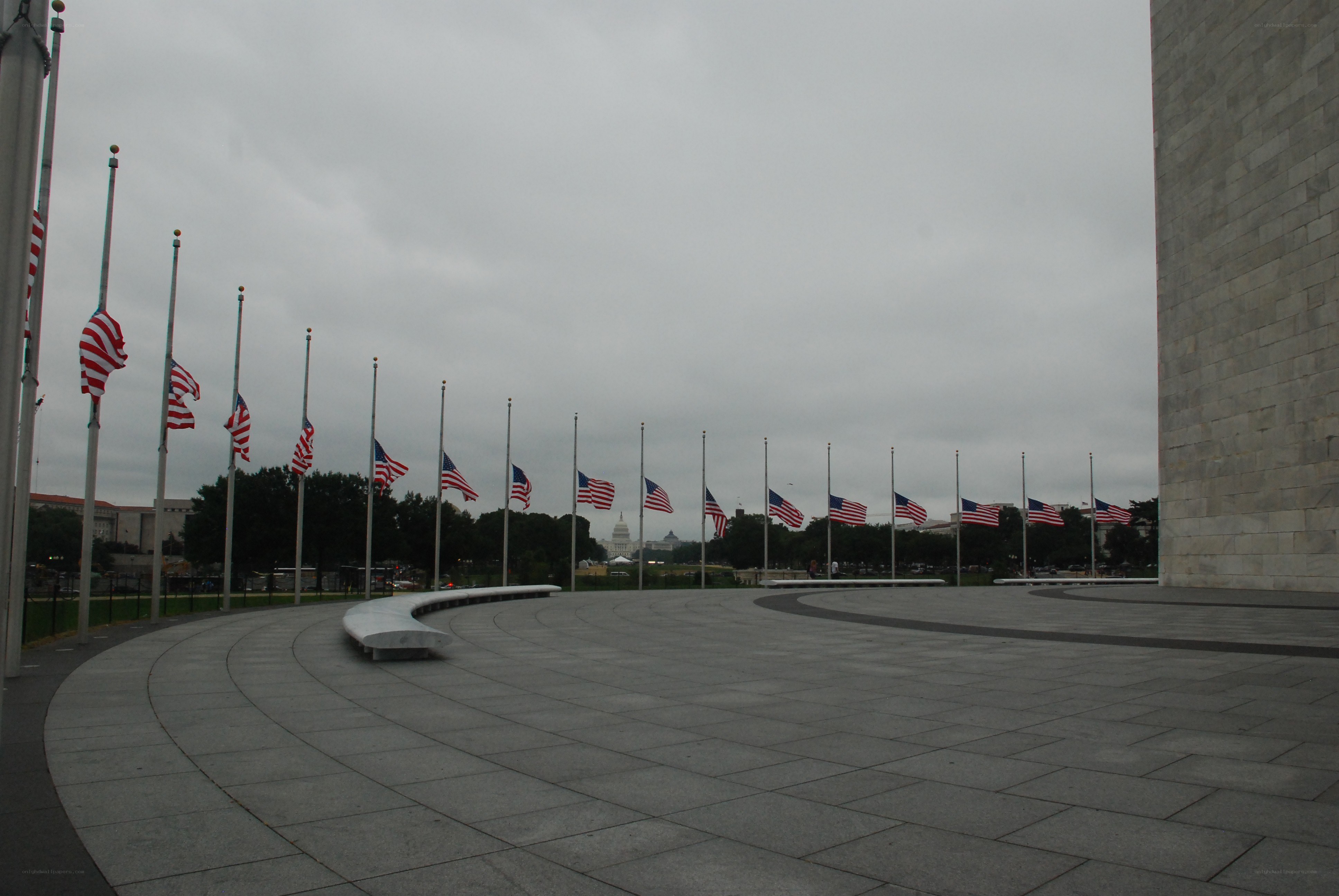 Flags at half-staff on a cloudy day