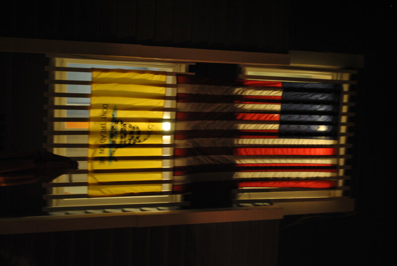 Flags behind a window at night