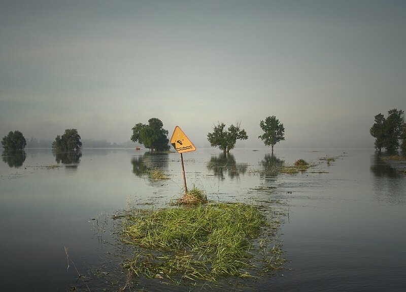 Flooded landscape with warning sign