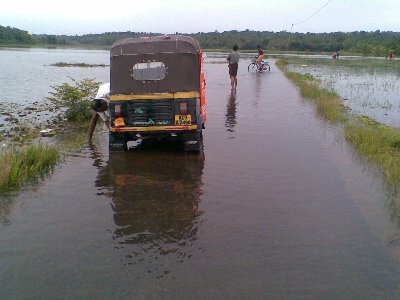 Flooded road with auto-rickshaw