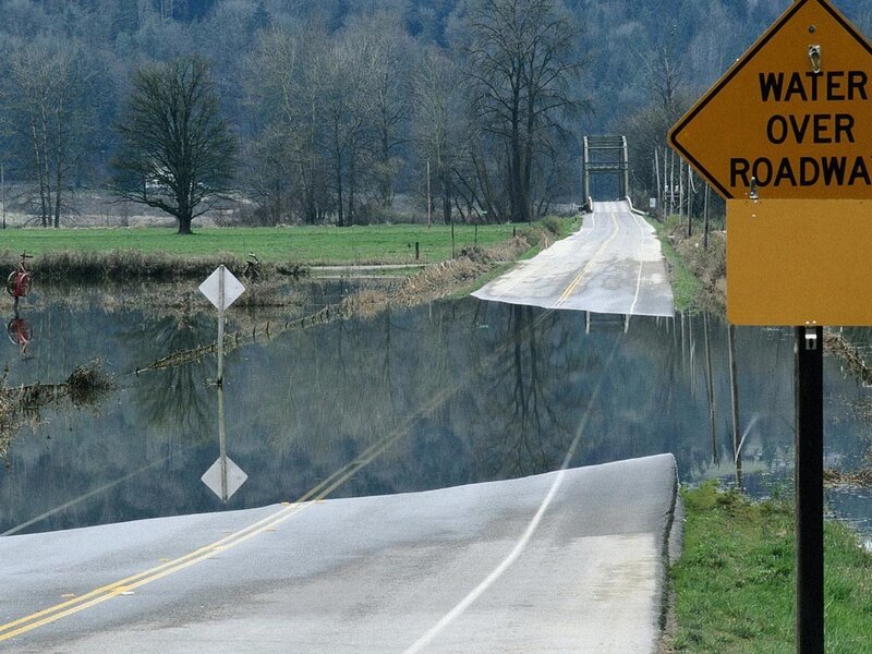Flooded road with water over roadway sign