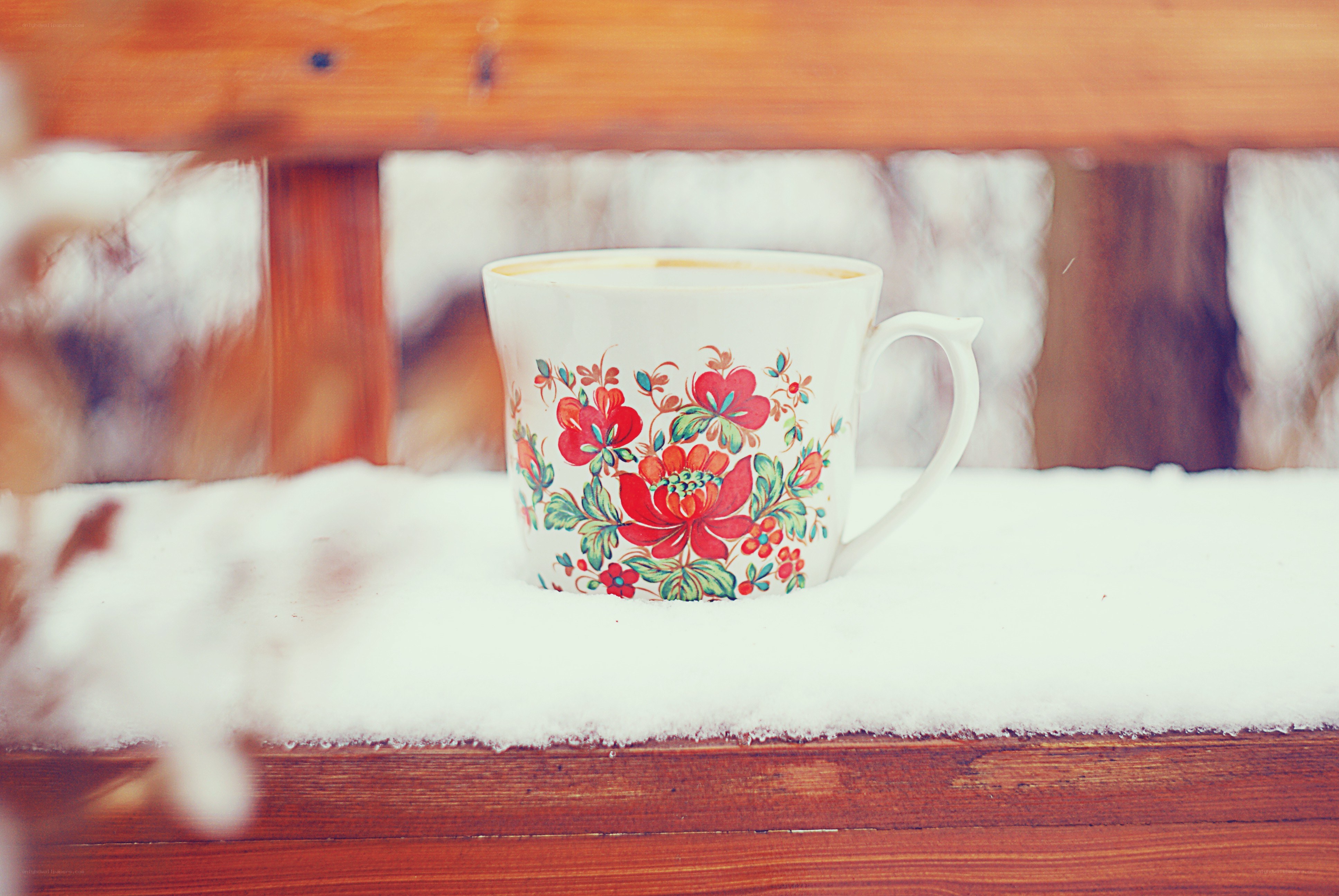 Floral mug on snowy bench
