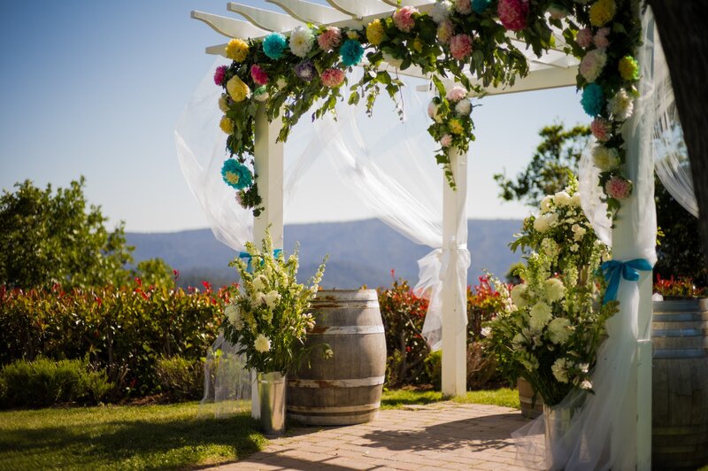 Floral wedding arch with vineyard view