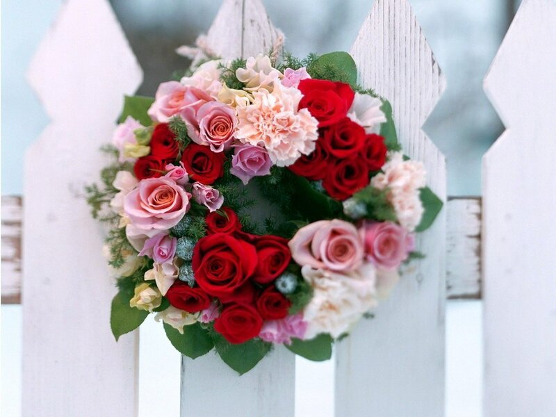 Floral wreath on white fence