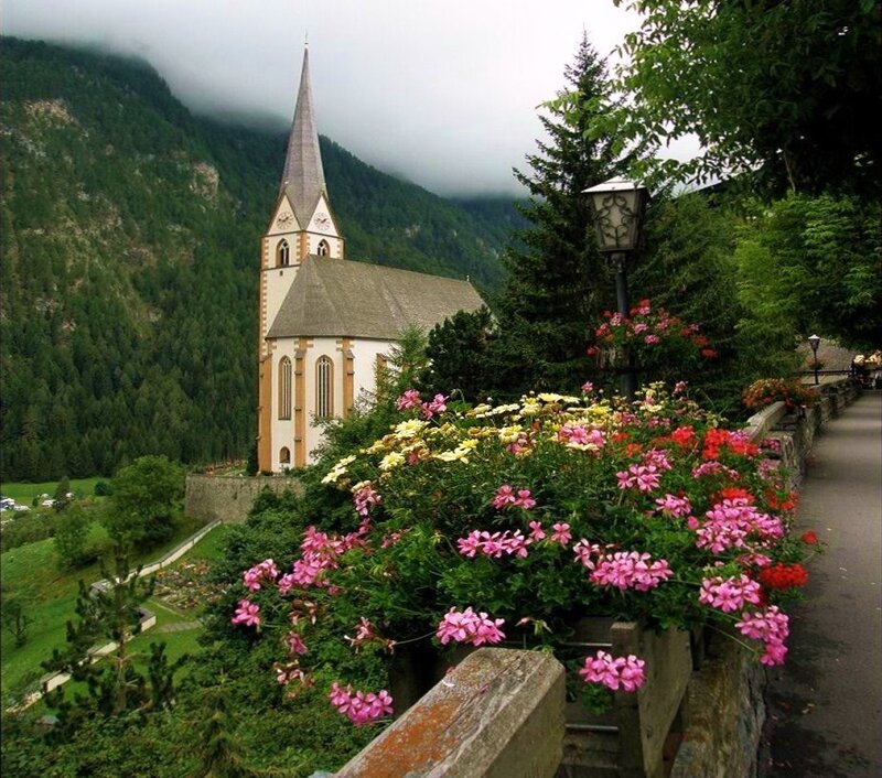 Flower-filled path near a mountain church