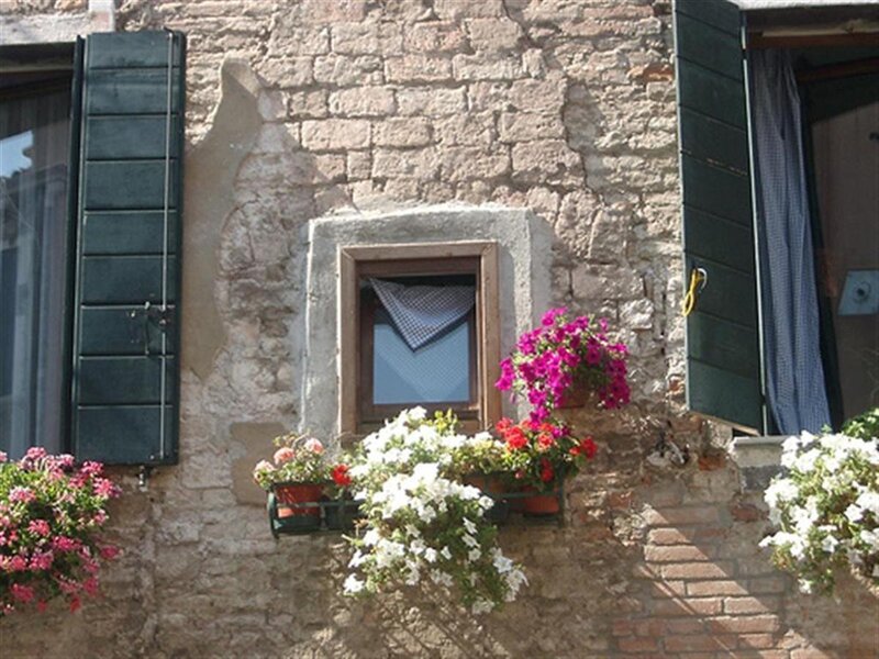 Flower-filled window in old stone building