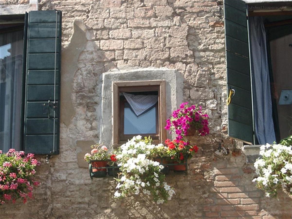 Flower-filled window in old stone building