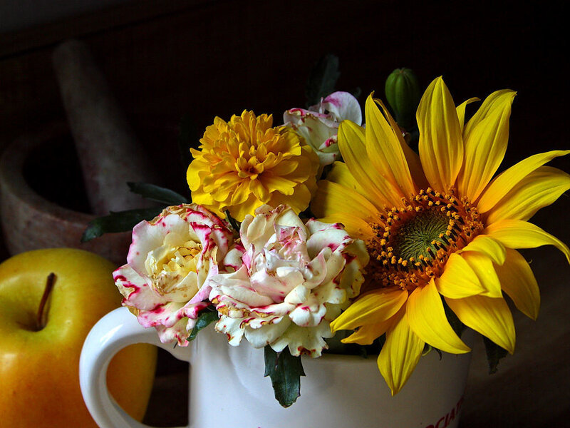 Flowers and apple in a mug