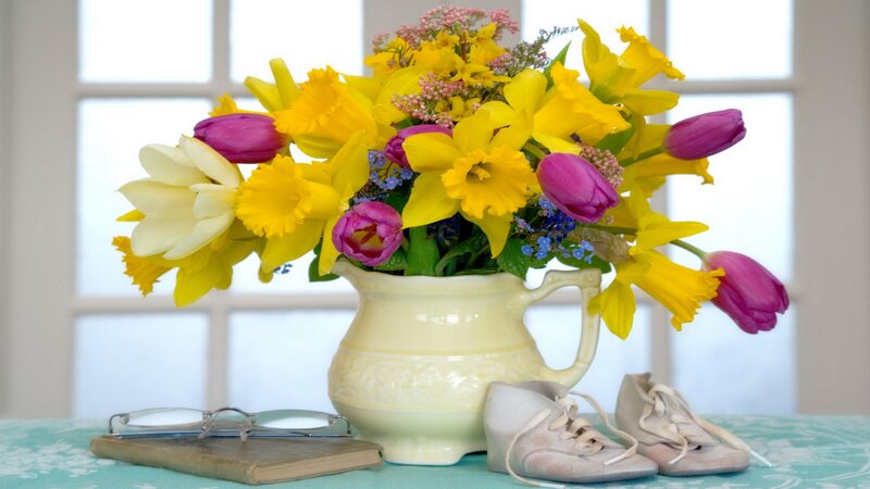 Flowers and baby shoes on table