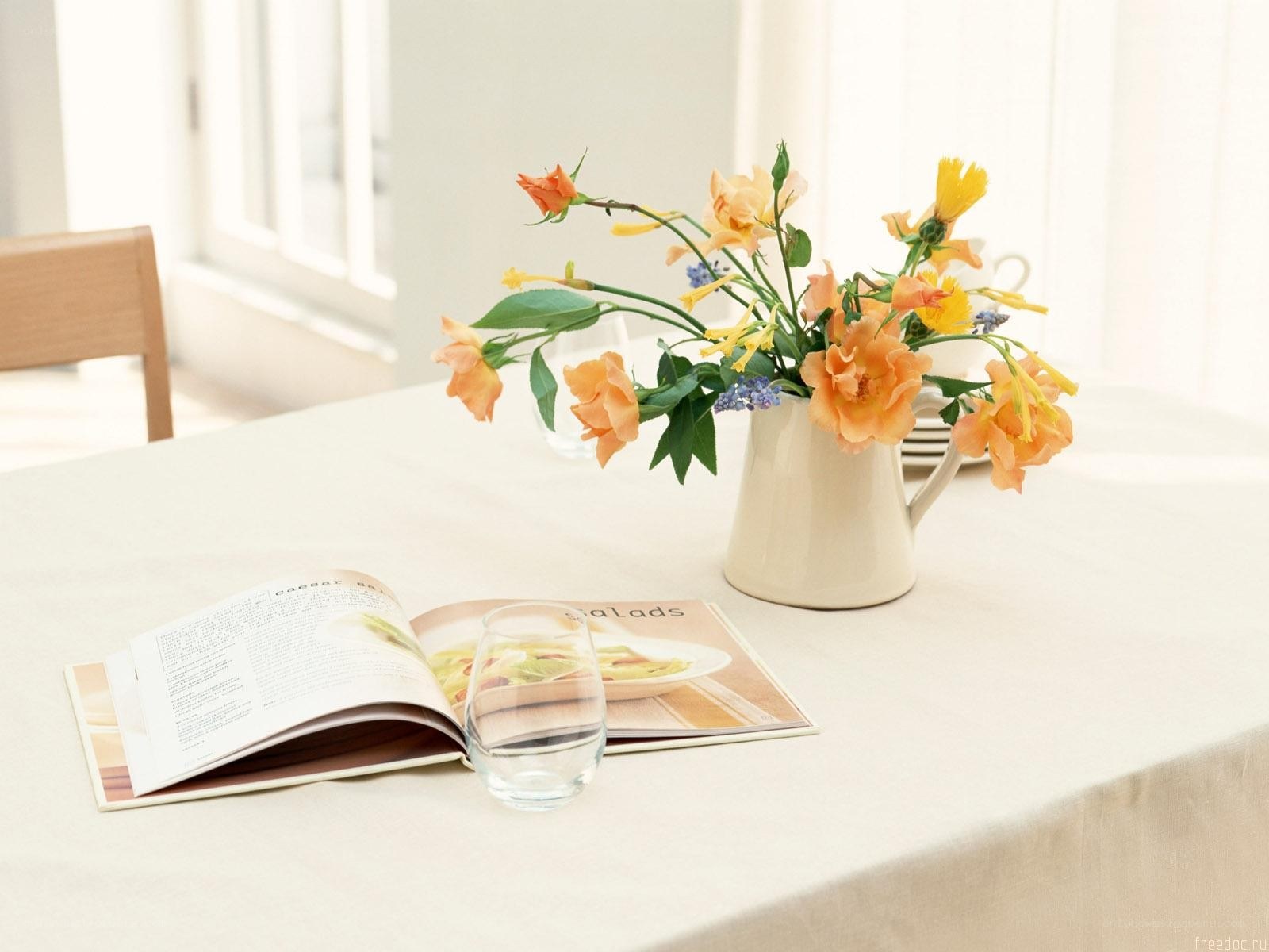 Flowers and cookbook on table