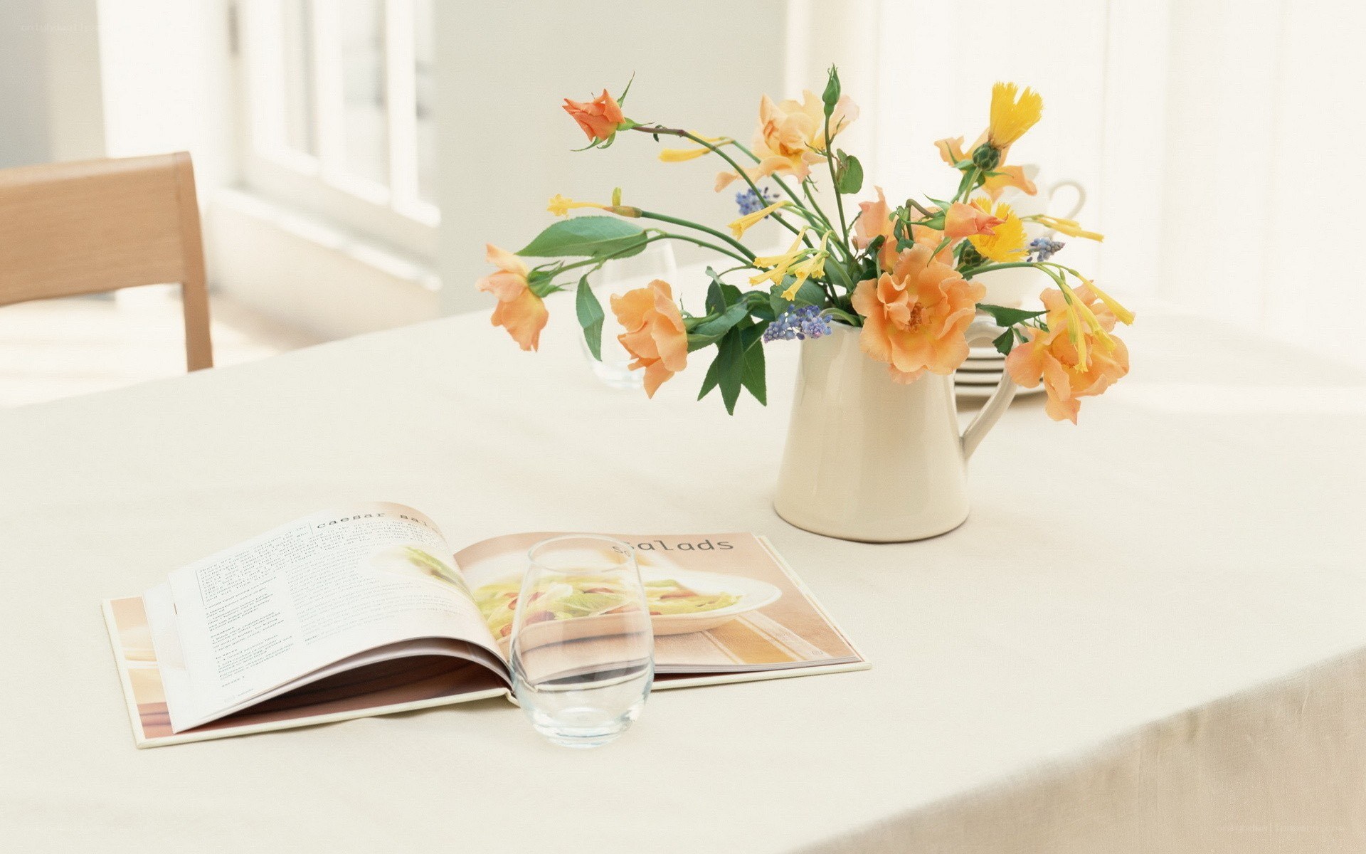 Flowers and cookbook on table