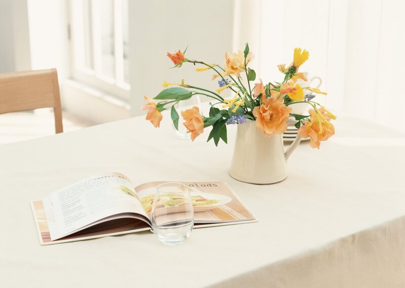 Flowers and cookbook on table