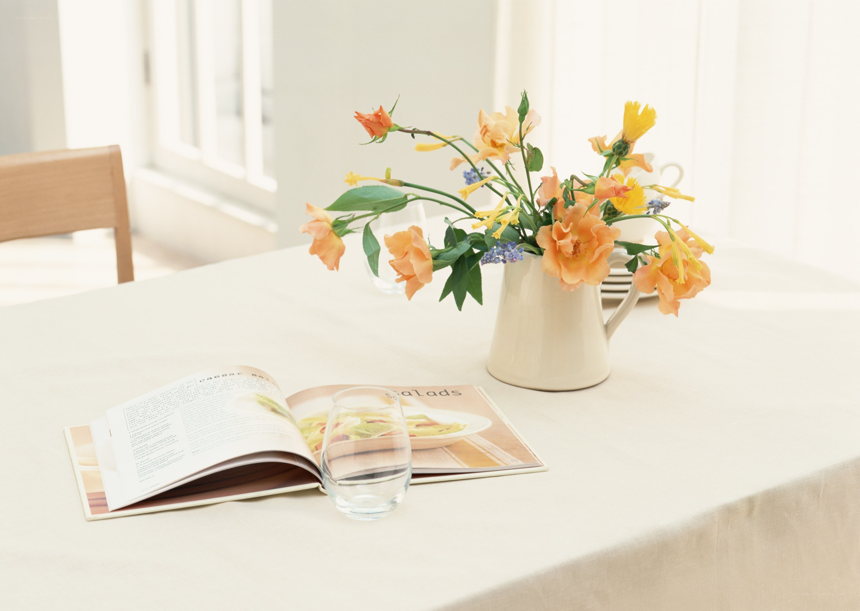 Flowers and cookbook on table