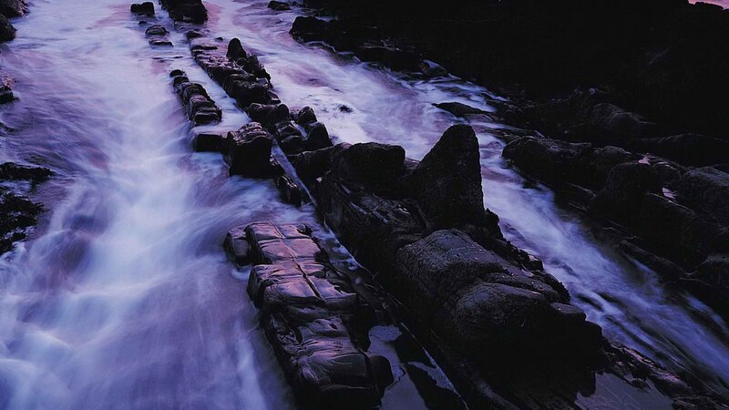 Flowing water over rocks at dusk