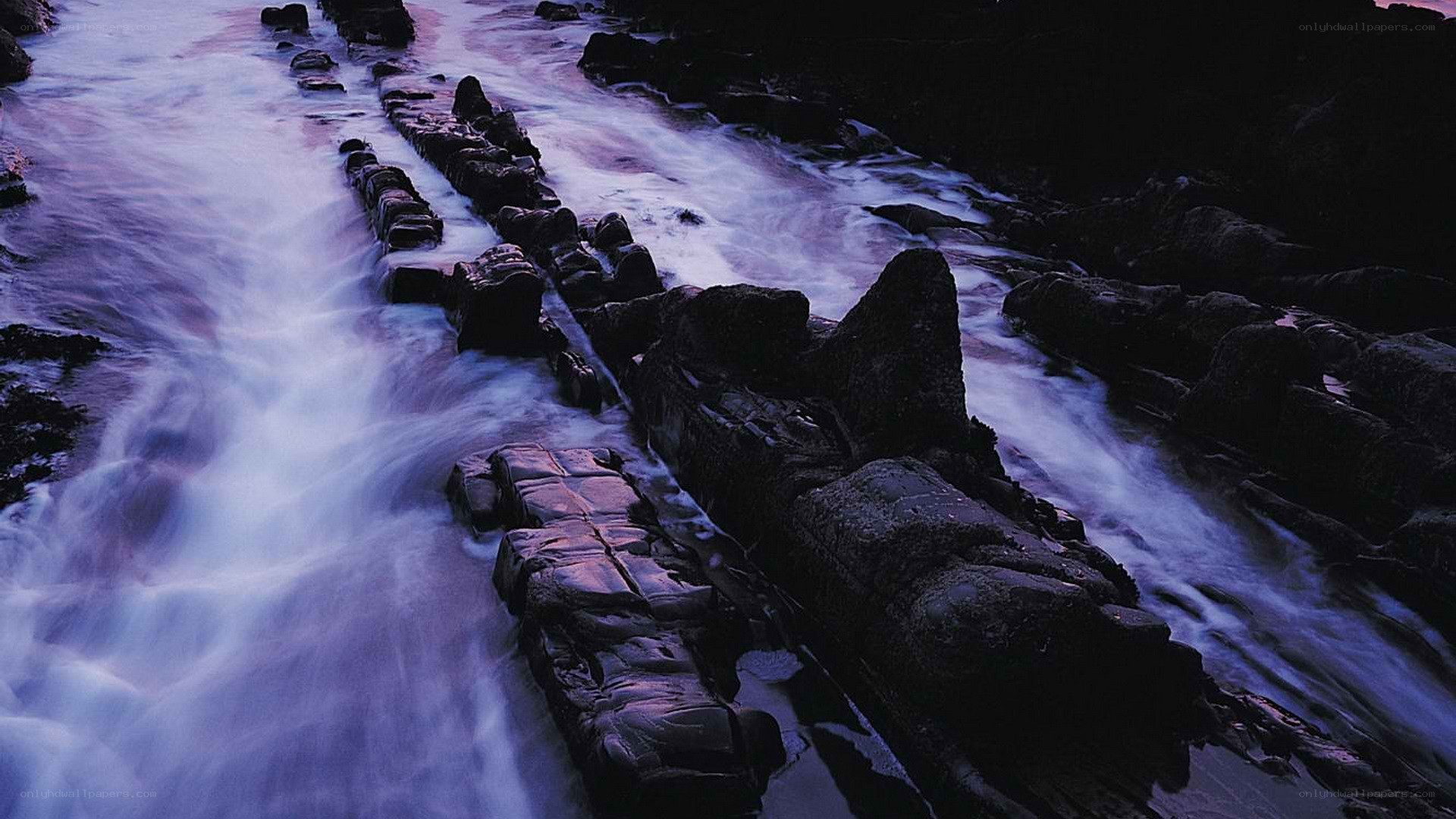 Flowing water over rocks at dusk
