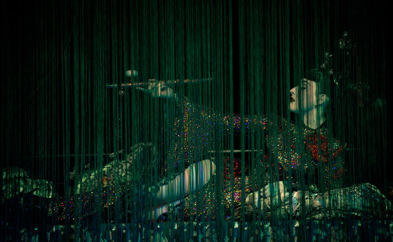 Flute player behind green curtain