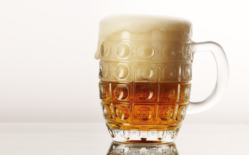 foamy beer in a glass mug