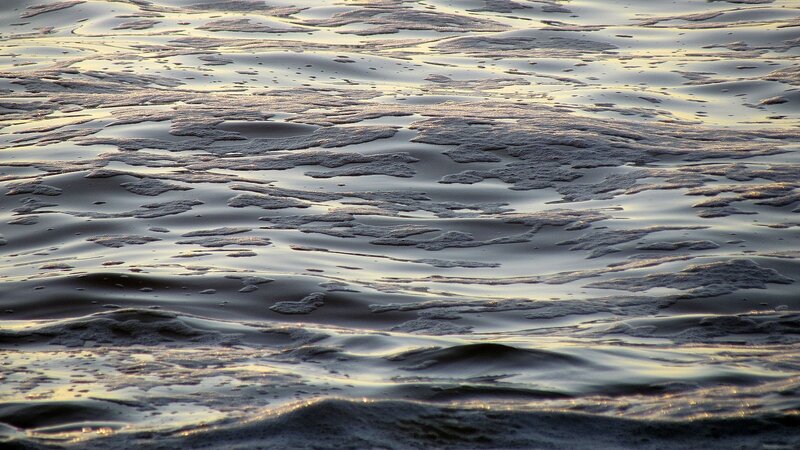 foamy water surface at sunset