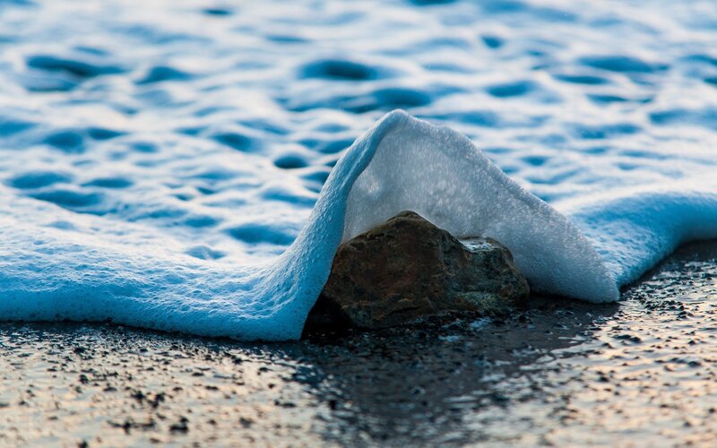 Foamy Wave Covering Rock