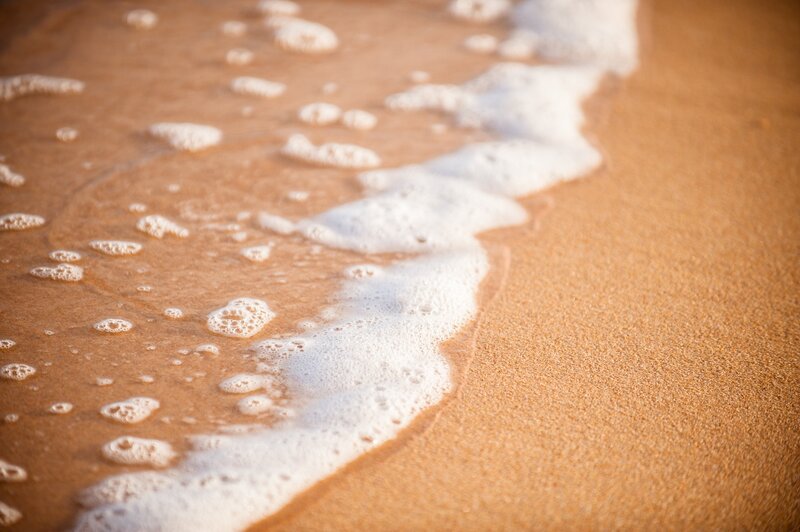 foamy wave on sandy beach