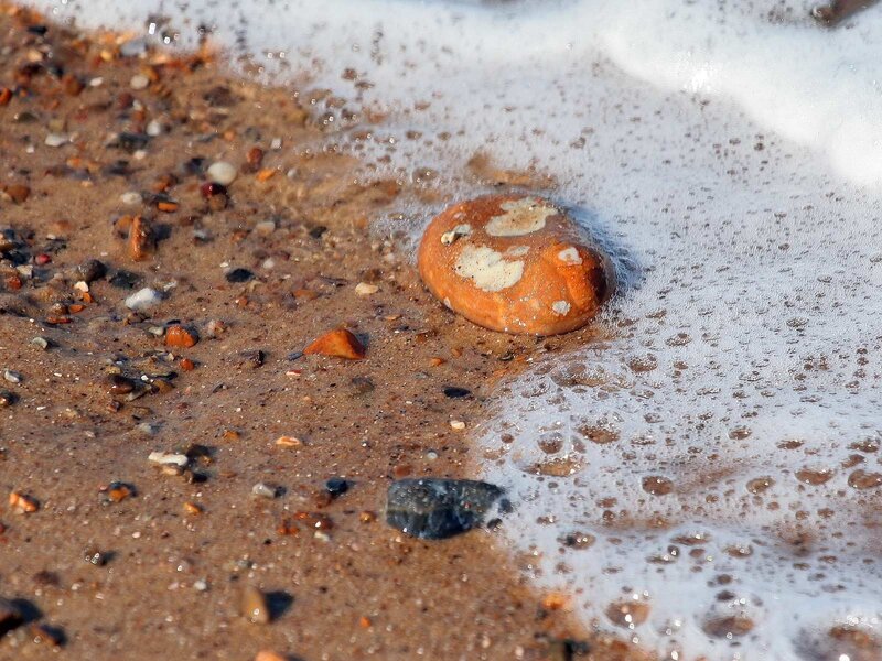 foamy waves on a pebble beach