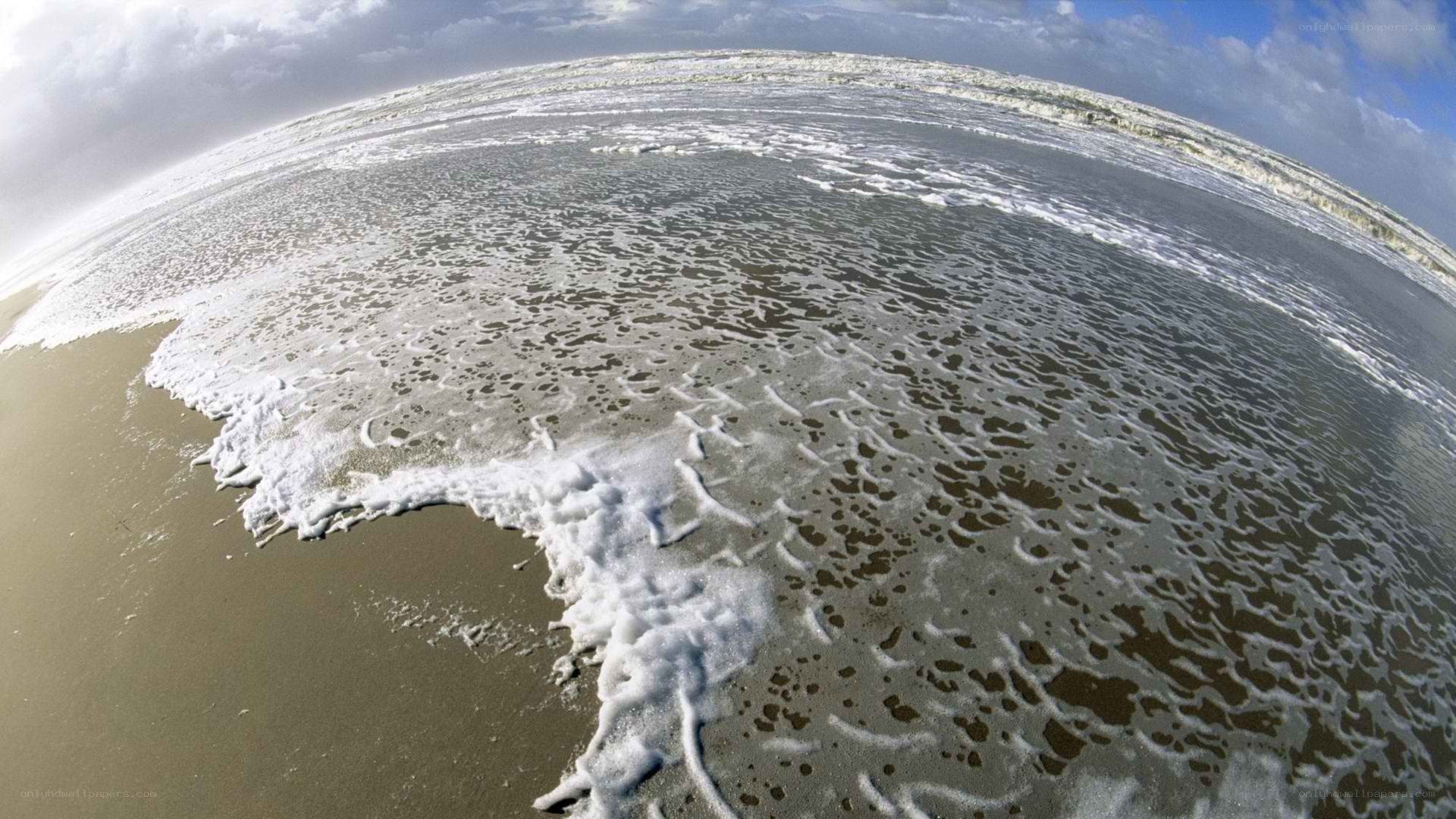 foamy waves on a sandy beach