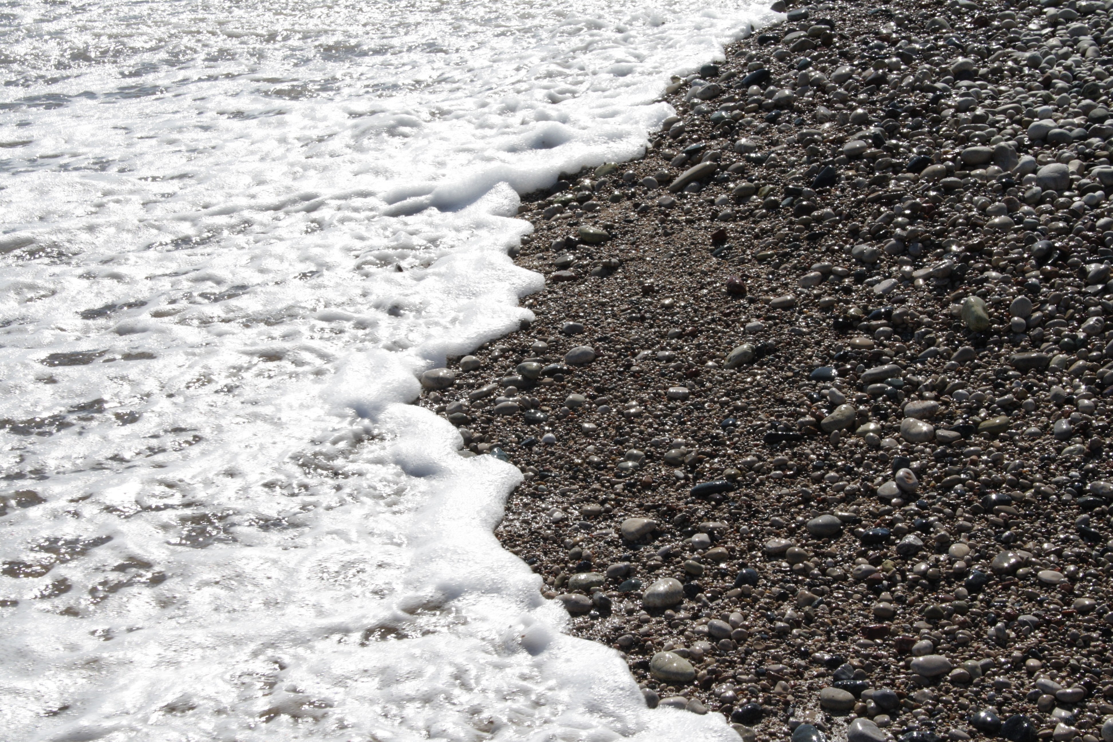 foamy waves on pebble beach