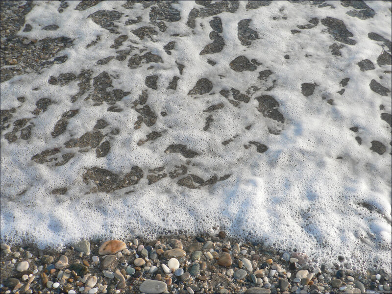 foamy waves on pebble beach