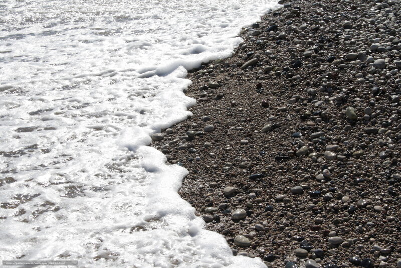 foamy waves on pebble beach