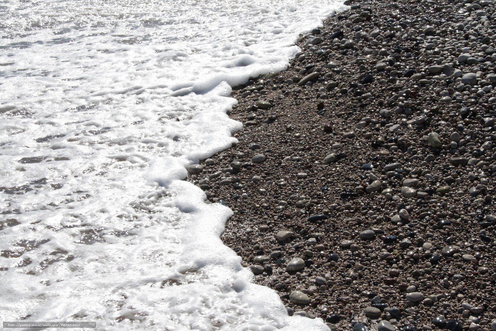 foamy waves on pebble beach