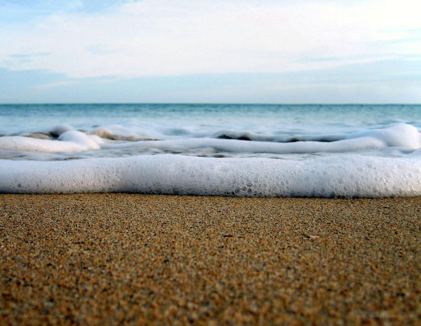 foamy waves on sandy beach
