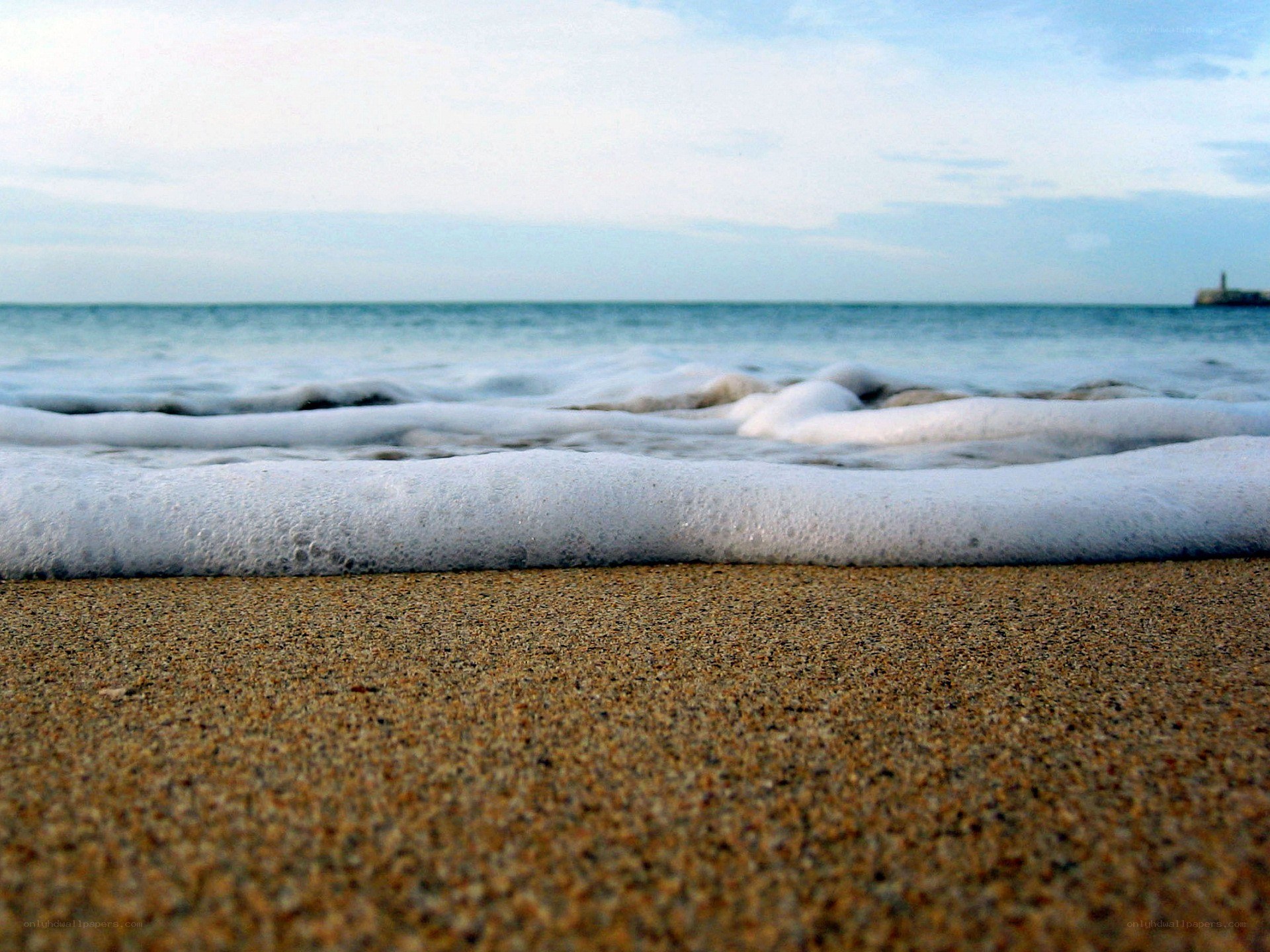foamy waves on sandy beach