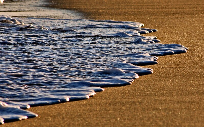 foamy waves on sandy beach